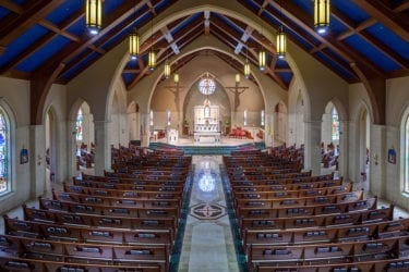 A spacious church interior featuring baptism furniture setup, with pews arranged neatly and a large altar at the front.