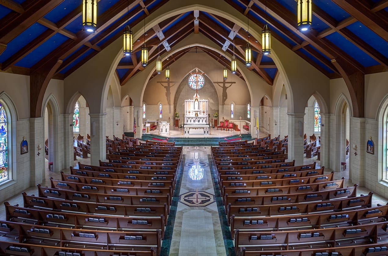 A spacious church interior featuring baptism furniture setup, with pews arranged neatly and a large altar at the front.